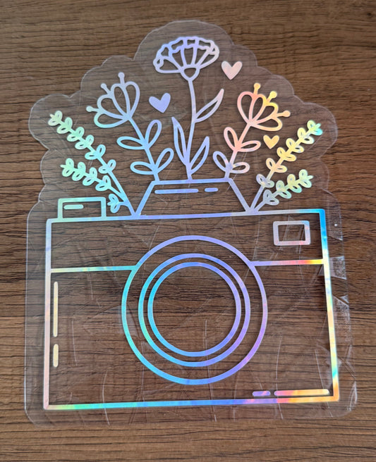 Floral camera rainbow window cling creating colorful prism reflections on a sunny window