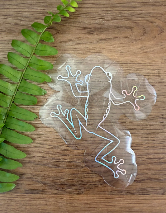 Handmade frog rainbow window cling made from diffraction film creating colorful rainbow prisms on a sunny window.