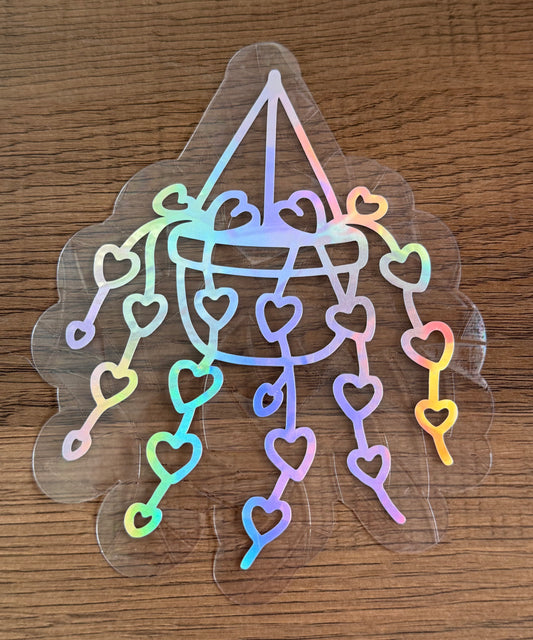 Heart chandelier rainbow window cling with hanging hearts creating colorful prism reflections on a sunny window