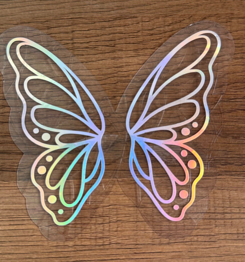 Butterfly wings rainbow window cling creating colorful prism reflections on a sunny window