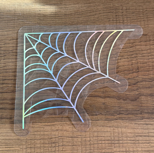 Corner spider web rainbow window cling catching sunlight and creating colorful prism reflections