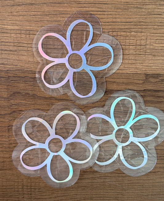 Set of three mini daisy rainbow window clings creating colorful prism reflections on a sunny window