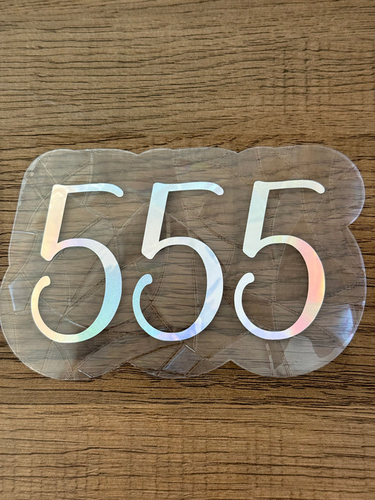555 angel number rainbow window cling displayed on a sunlit window